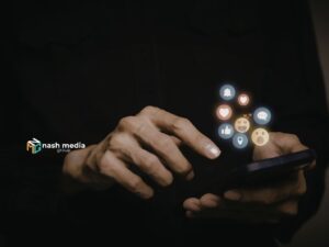 Hand interacting with smartphone showing social media reaction icons and engagement metrics