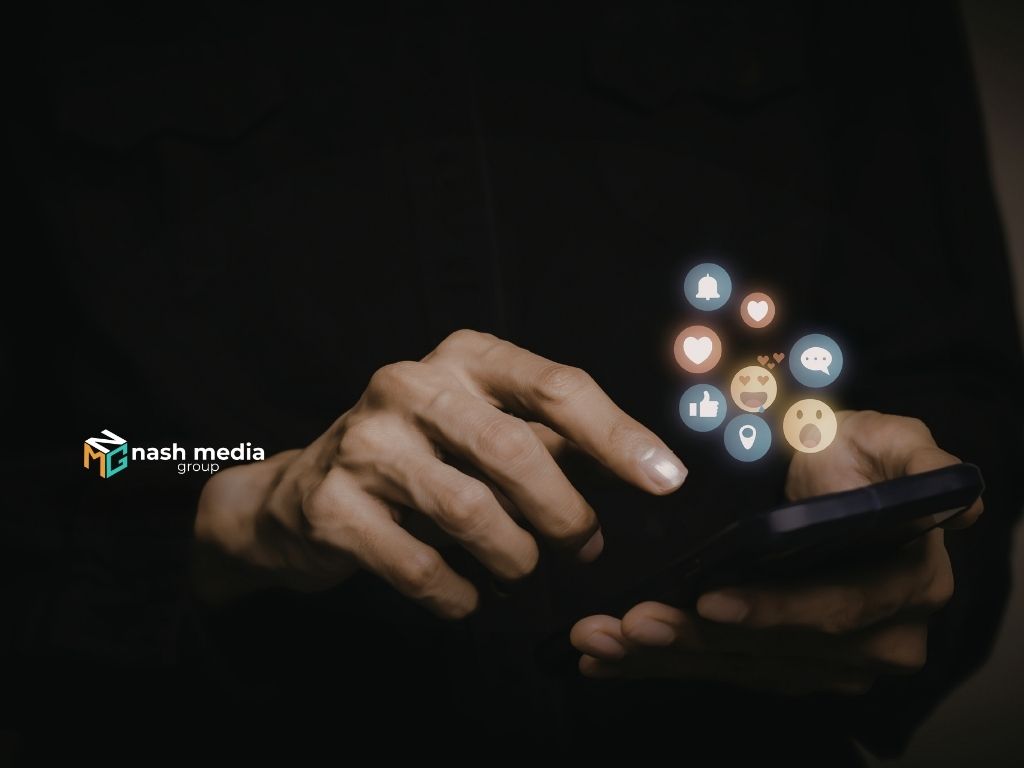 Hand interacting with smartphone showing social media reaction icons and engagement metrics