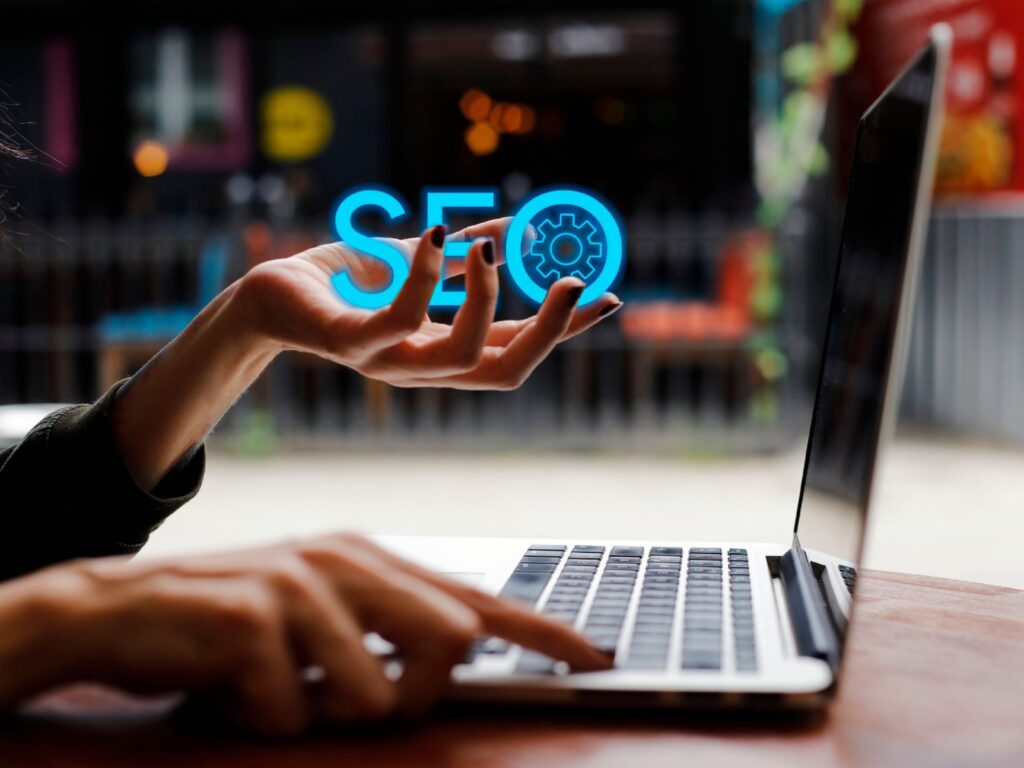 A hand holding to an overlay "SEO" text